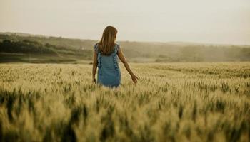 vista posteriore alla giovane donna incinta nel campo foto