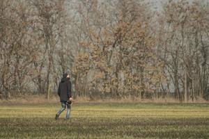 un uomo con una macchina fotografica sta camminando sul campo foto