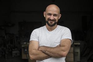 ritratto di falegname calvo bianco con barba in t-shirt bianca. isolare su uno sfondo nero foto