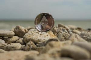 criptovaluta ethereum. valuta elettronica. spiaggia estiva. pietre di mare foto