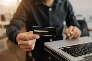 mani della donna d'affari utilizzando smartphone e tenendo la carta di credito come shopping online foto