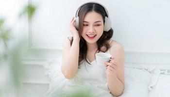 immagine di giovane donna asiatica che ascolta musica a casa al mattino foto