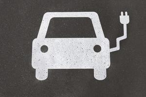 simbolo della stazione di ricarica per auto elettriche dipinto su asfalto - concetto di mobilità elettrica foto