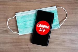mock-up corona app su smartphone o cellulare e maschera facciale foto
