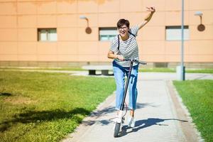 donna in giro per la città su uno scooter elettrico foto