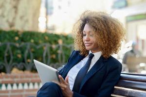 donna di colore che utilizza computer tablet in città