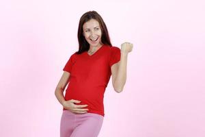 giovane e bella donna nuova madre alza il pugno con eccitato e sicuro di sé. concetto di mamma felice e orgogliosa, amore e speranza per la nascita del bambino a breve foto