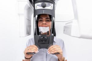 donna con la faccia in una macchina per lo sbiancamento dei denti in una clinica odontoiatrica foto