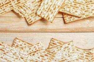 sfondo per la tradizionale festa ebraica di Pesach. pane matzo pasquale su un tavolo di legno. foto