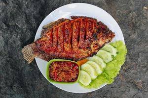 deliziosa tilapia grigliata dall'indonesia con riso, tempeh, verdure e salsa al peperoncino nel piatto foto