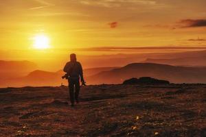 uomo felice in piedi su una scogliera al tramonto foto