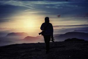 uomo felice in piedi su una scogliera al tramonto foto