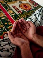 la mano del bambino musulmano mentre prega foto