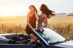 due donne in un'auto nera sulle strade lungo la strada foto