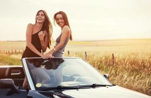 due donne in un'auto nera sulle strade lungo la strada foto