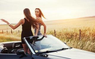 due donne in un'auto nera sulle strade lungo la strada foto