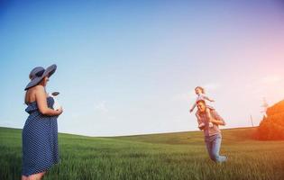 felice famiglia di tre persone che si abbracciano per le strade foto