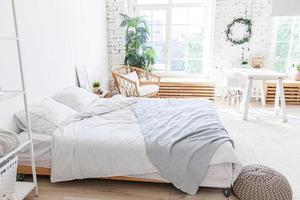 interni eleganti della camera da letto soppalcata. appartamento di design spazioso con pareti chiare grandi finestre letto grande. arredamento moderno e pulito con mobili eleganti in stile scandinavo minimalista. foto