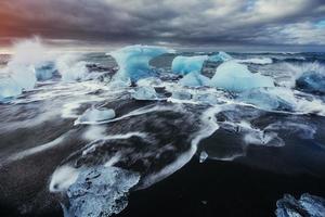 ghiacciaio sulla spiaggia vulcanica nera islanda foto