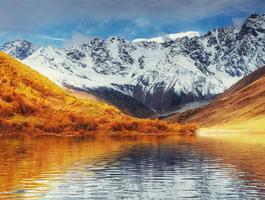 montagne innevate nella nebbia. autunno al lago koruldi foto