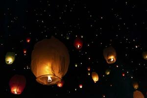 le lanterne volano nel cielo notturno foto