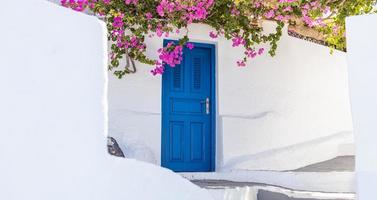 fantastico sfondo di viaggio, paesaggio urbano di santorini. porta blu con scale e fiori, architettura bianca sotto il cielo blu. idilliaco concetto di vacanza estiva vacanza. meravigliose vibrazioni di lusso estive foto
