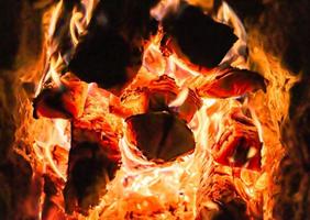 bellissimo camino antico con fuoco a fiamma leggera per il riscaldamento della stanza dell'edificio foto