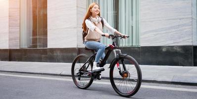 giovane donna asiatica che usa la bicicletta come mezzo di trasporto foto