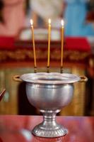nella chiesa si accendono le candele ed è il rito del battesimo del bambino foto