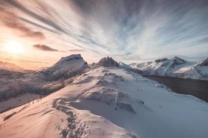 paesaggio di colorata collina innevata con impronta all'alba foto