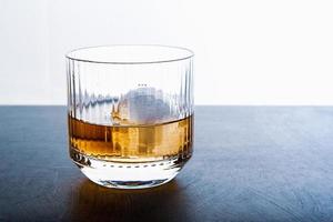 cubetto di ghiaccio a forma di sfera e vista ravvicinata del whisky dallo studio. foto