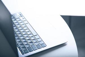 vista laterale del profilo di un laptop su bianco con illuminazione retroilluminata. include spazio di copia. foto
