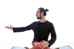 giovane uomo bianco dai capelli lunghi caucasico sta eseguendo yoga in uno studio o in una casa. foto