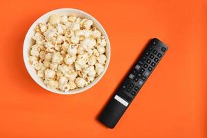 ripresa aerea di popcorn e telecomando è una buona partita per guardare gli sport dal vivo. o serie TV e vari programmi di intrattenimento nel tempo libero in vacanza in famiglia è una buona attività per la famiglia. foto