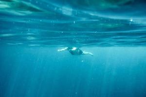 uomo che nuota nell'oceano blu foto