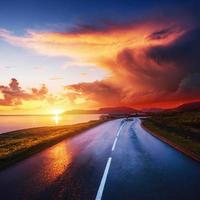 strada asfaltata lungo il mare al tramonto islanda foto