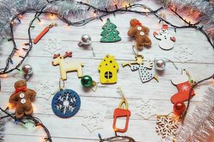 addobbi natalizi e luci a ghirlanda su sfondo bianco in legno foto
