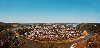 vista panoramica della piccola città penisola rotonda con fiume e ponte in autunno. zalischyky, ucraina europa foto