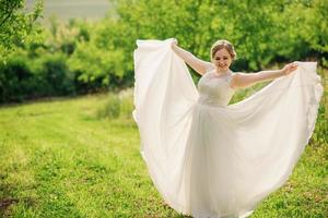 giovane ragazza in sovrappeso in abito beige poste sfondo giardino primaverile. foto