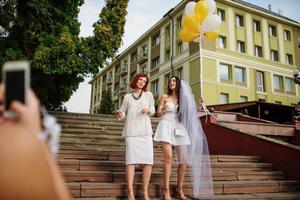 due ragazze con palloncini a portata di mano su addio al nubilato. fare foto per telefono.