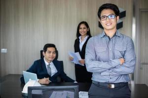 uomo d'affari asiatico e gruppo che utilizza il taccuino per riunioni e uomini d'affari che sorridono felici per il lavoro foto