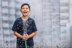 ragazzo asiatico lavarsi i denti con schiuma che esce dalla sua bocca foto