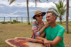 coppia seduta in un piccolo parco vicino alla spiaggia di caraiva bahia, brasile foto