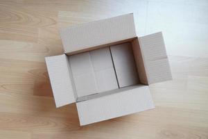 scatola di cartone vuota su pavimento laminato foto