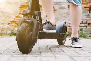 gambe di persona irriconoscibile con monopattino elettrico o e-scooter foto