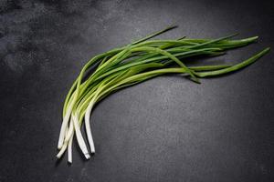 cipolla verde o scalogno su tavola di legno, erba cipollina fresca di primavera foto