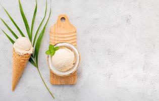 gusti di gelato al cocco a metà della configurazione di cocco su sfondo di pietra bianca. concetto di menu estivo e dolce.