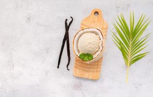 gusti di gelato al cocco a metà della configurazione di cocco su sfondo di pietra bianca. concetto di menu estivo e dolce.