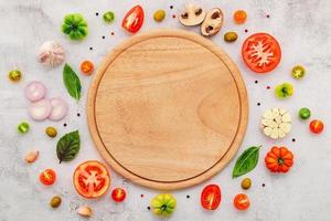 gli ingredienti per la pizza fatta in casa allestiti su sfondo bianco di cemento. foto