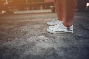 due ragazze in piedi una accanto all'altra che indossano scarpe bianche. foto